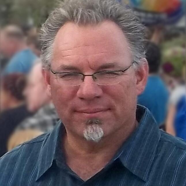 Close up image of a man with white hairs and beard