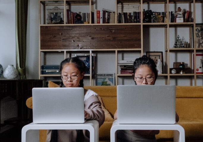 Two girl students working or reading on computer